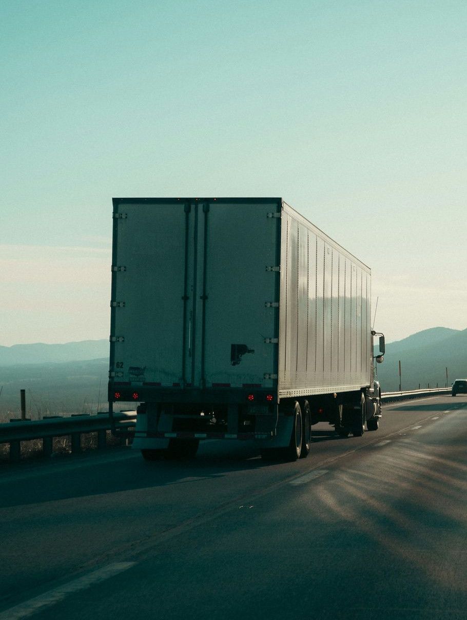 Two semi-trucks driving on a highway